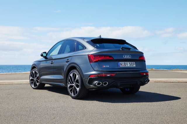 Rear three-quarter view of a grey 2024 Audi SQ5 Sportback parked near the ocean.