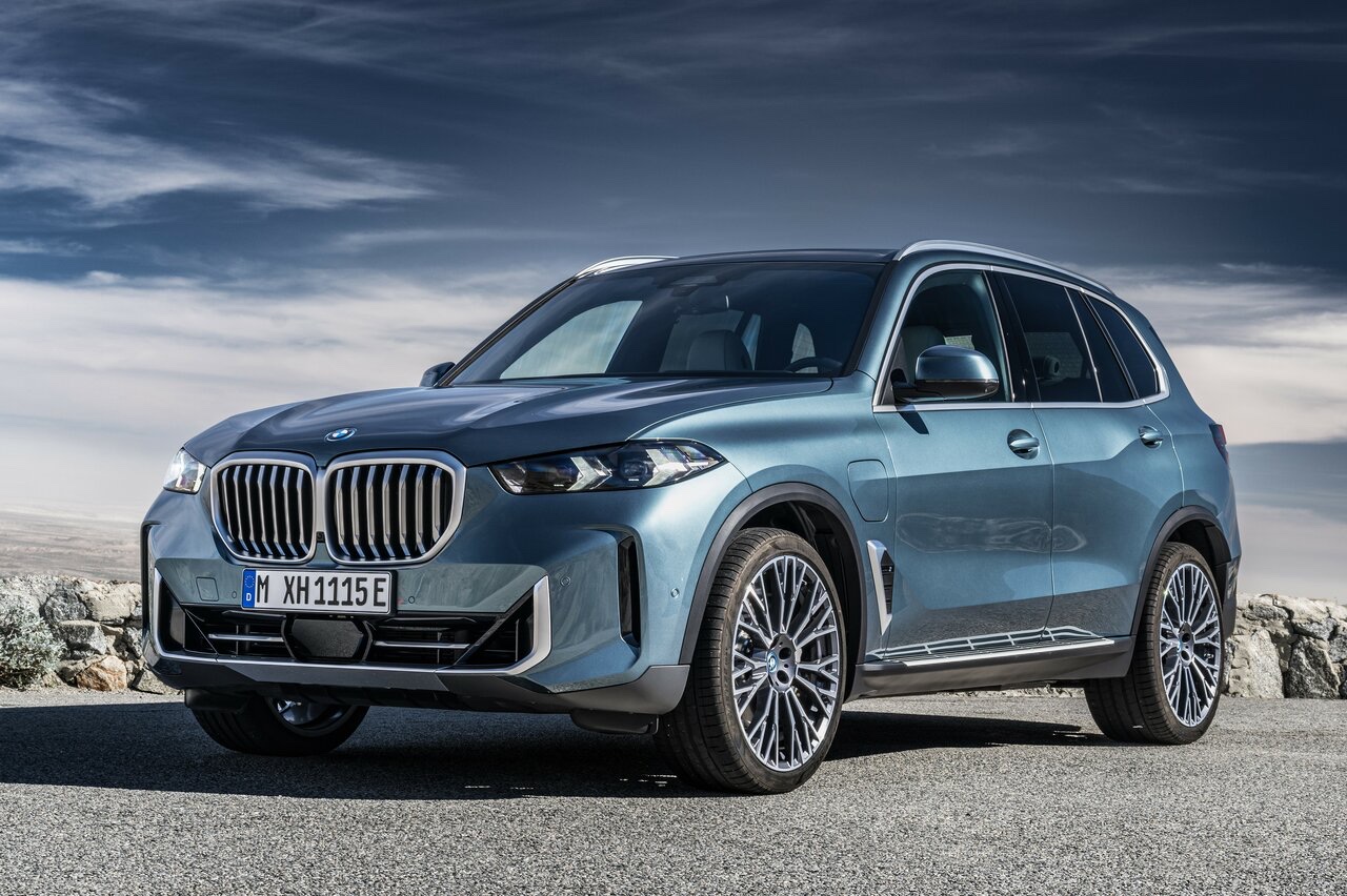 Front three-quarter view of a metallic blue 2023 BMW X5 SUV parked on a paved road.