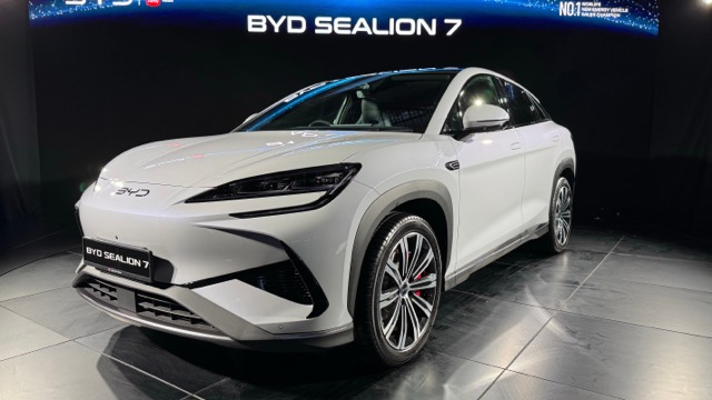 Front three-quarter view of a white 2024 BYD Sealion 07 EV on display indoors.