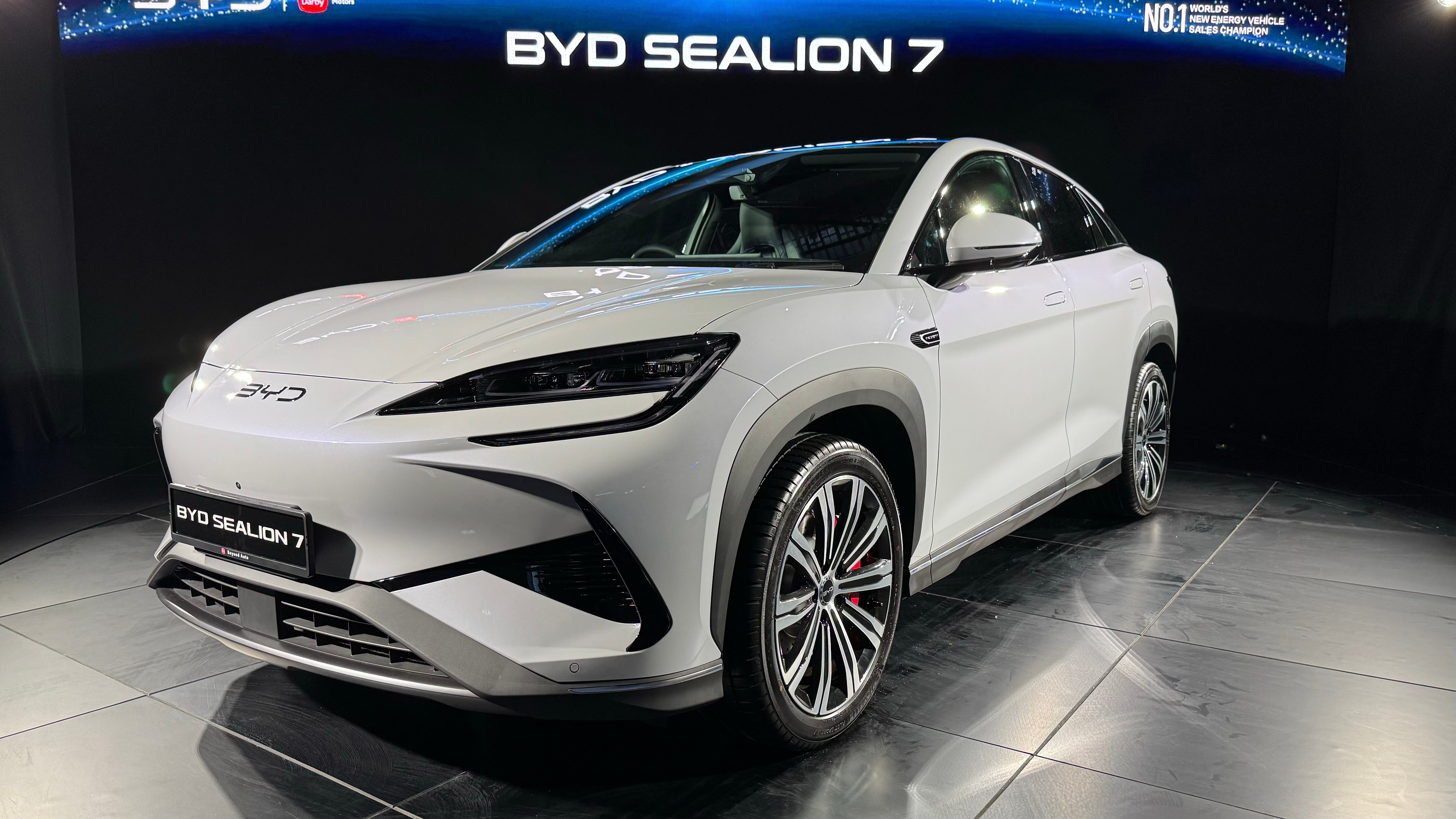 Front three-quarter view of a white 2024 BYD Sealion 07 EV on display indoors.