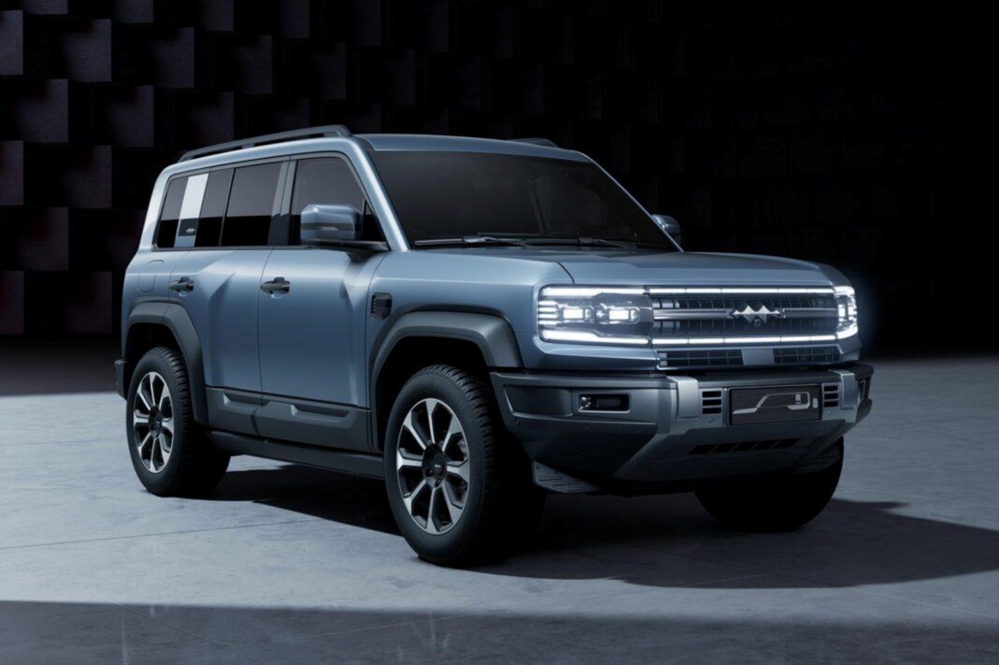 Front three-quarter view of a light blue 2023 BYD Leopard 5 SUV in a dark studio setting.